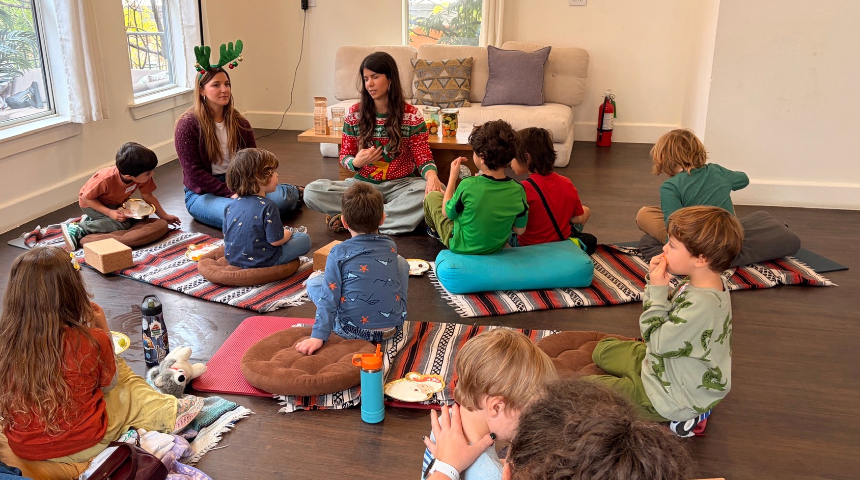 Dr. Laura leading a healthy living class with children seated on cushions