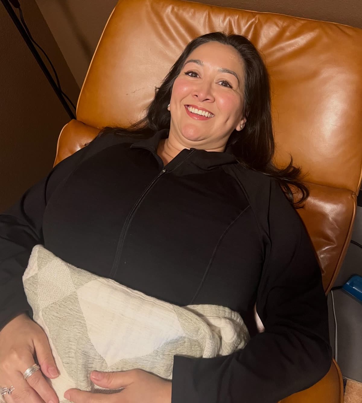 A smiling patient relaxing in a chair after her adjustment