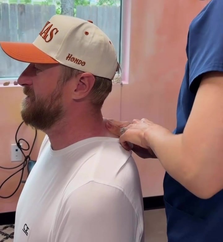 Dr. Laura gently checking a patient's neck and shoulders